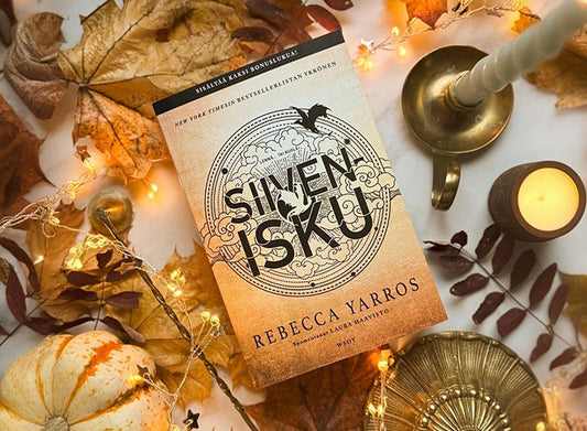 Rebecca Yarrosin Sivenisku-kirja syksyisten koristeiden keskellä pöydällä.