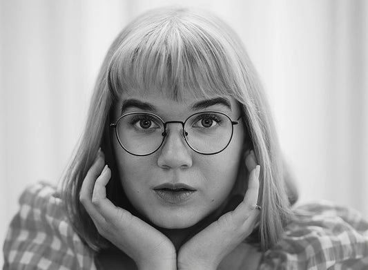 Mustavalkoinen muotokuva kirjailija Ulla Onervasta. Hän katsoo suoraan kameraan leuka käsien varassa, sormet poskilla. Hänellä on suorat vaaleat hiukset, otsatukka ja pyöreät silmälasit. Yllään hänellä on ruudullinen pusero, ja taustalla on vaalea, pehmeä