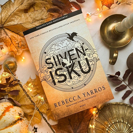 Rebecca Yarrosin Sivenisku-kirja syksyisten koristeiden keskellä pöydällä.