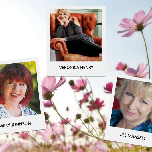 Kolmen hyvän mielen kirjailijan esittelykuva kesäisten kukkien taustalla. Kuvassa hymyilevät Veronica Henry, Milly Johnson ja Jill Mansell. Taustalla näkyy vaaleanpunaisia kukkia ja sininen taivas.