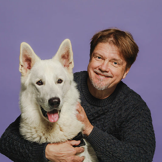 Kirjailija Timo Parvela ja vaalea koira.