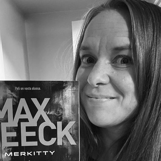 Mustavalkoinen lähikuva Satu Rämöstä pitelemässä Max Seeckin Merkitty-kirjaa