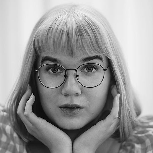 Mustavalkoinen muotokuva kirjailija Ulla Onervasta. Hän katsoo suoraan kameraan leuka käsien varassa, sormet poskilla. Hänellä on suorat vaaleat hiukset, otsatukka ja pyöreät silmälasit. Yllään hänellä on ruudullinen pusero, ja taustalla on vaalea, pehmeä