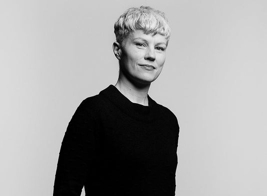 Mustavalkoinen muotokuva Johanna Forssista. Hänellä on lyhyet, vaaleat hiukset ja yllään musta pitkähihainen paita. Hän seisoo vaaleaa taustaa vasten vartalo hieman sivuttain kameraan nähden.