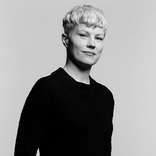 Mustavalkoinen muotokuva Johanna Forssista. Hänellä on lyhyet, vaaleat hiukset ja yllään musta pitkähihainen paita. Hän seisoo vaaleaa taustaa vasten vartalo hieman sivuttain kameraan nähden.