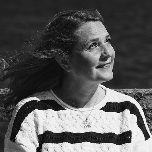 Mustavalkoisessa puolikuvassa penkillä istuva Leena Paasio.