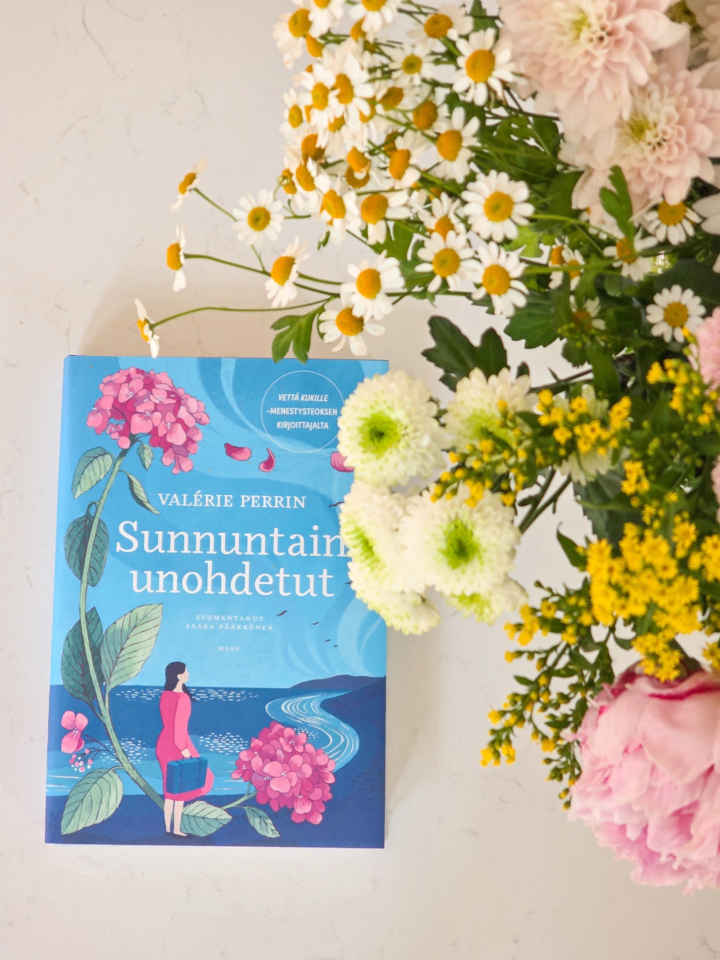 Sunnuntain unohdetut -kirja ja kukkakimppu
